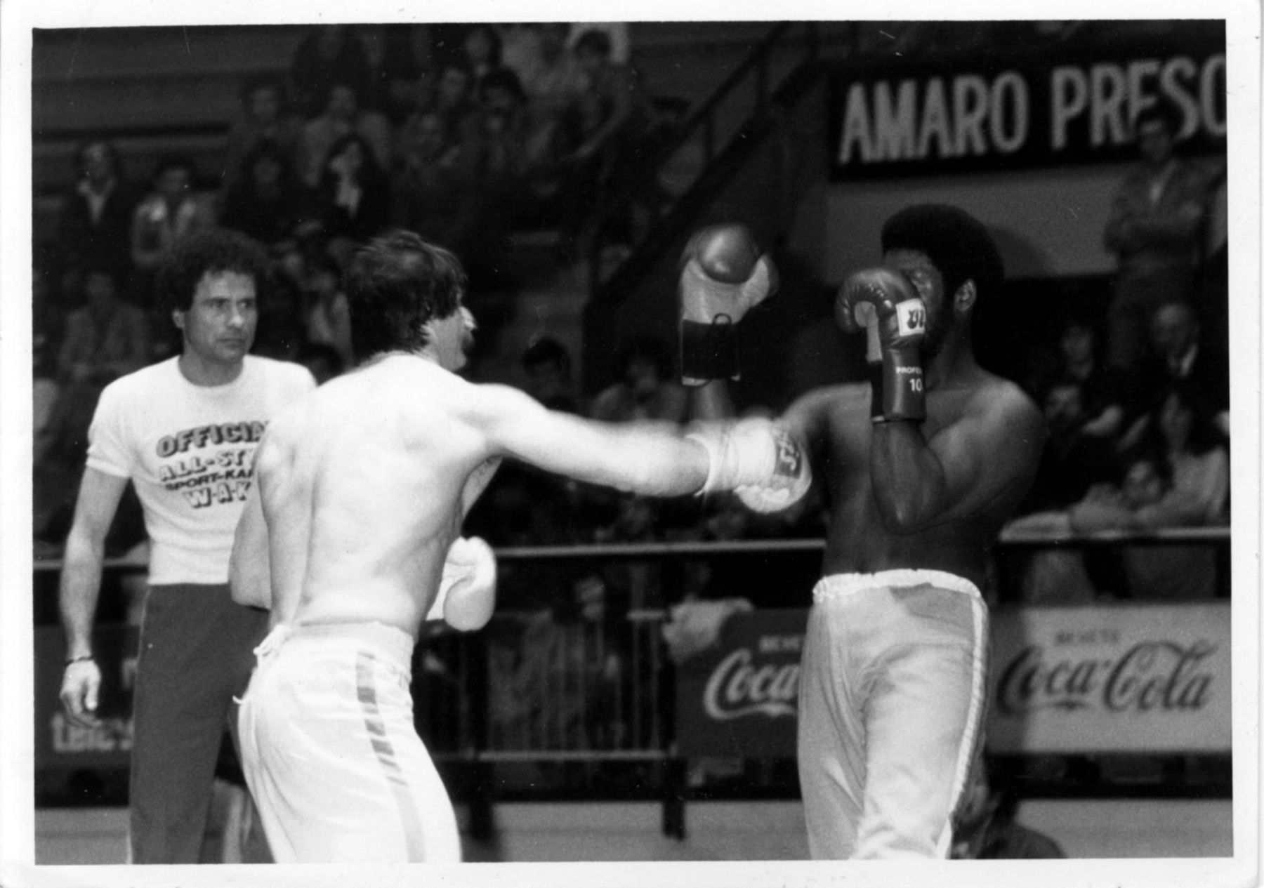 Due atleti si affrontano in un incontro in palestra, foto in bianco e nero.
